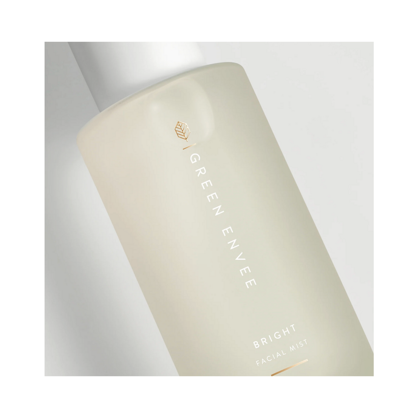 لقطة مقربة تفصيلية لزجاجة رذاذ الوجه Green Envee Brightening Facial Mist، مع التركيز على الشعار المنقوش بالذهب والعلامة التجارية للعناية بالبشرة النظيفة.