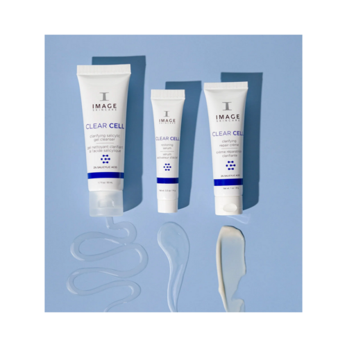 Flat lay of Image Skincare CLEAR SKIN SOLUTIONS Blemish Defense Trio with visible gel and cream textures on blue background.