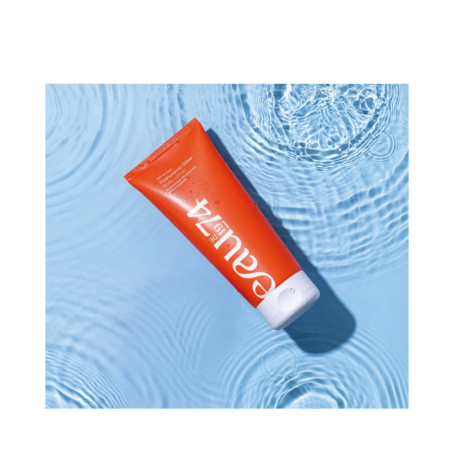 EAUde1974 Hyaluronic Glow קרם גוף על רקע מים כחולים
