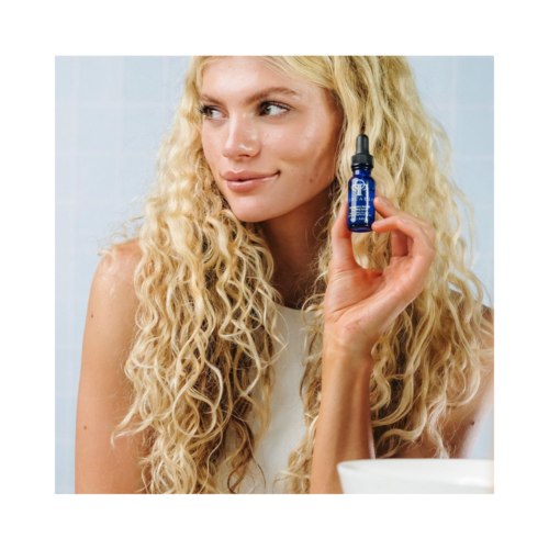 Smiling woman displaying Circadia Emergency Eye Lift for Youthful Eyes, promoting its use for youthful, lifted under-eye skin.