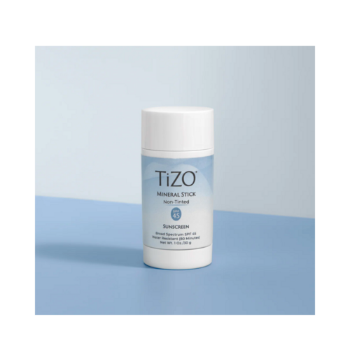 TiZO Mineral Stick Non Tinted קרם הגנה SPF 45 על משטח כחול, המדגיש את הגנת השמש שלו עם ספקטרום רחב ועמיד במים.