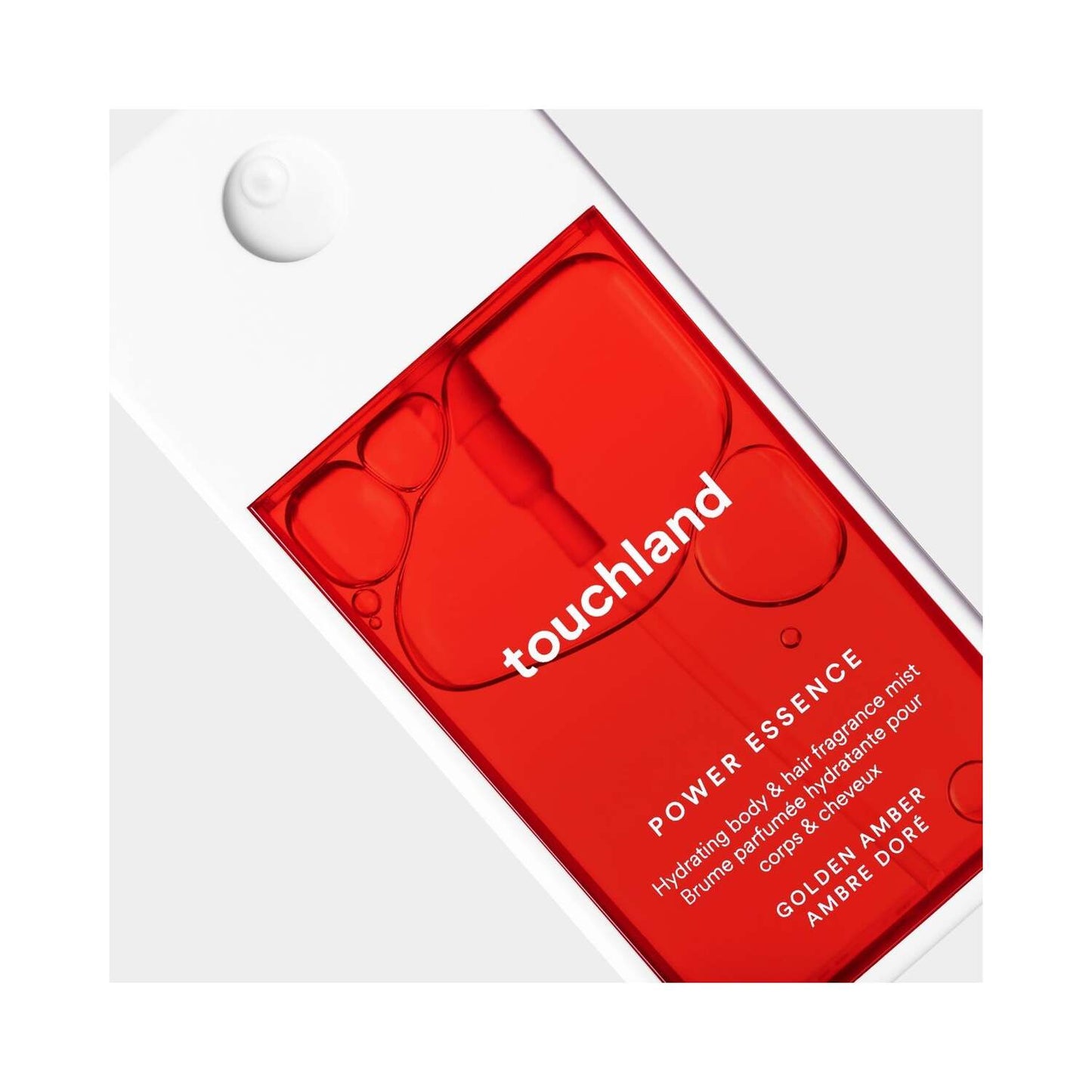 Primer plano de la niebla de fragancia Touchland Power Essence con líquido rojo