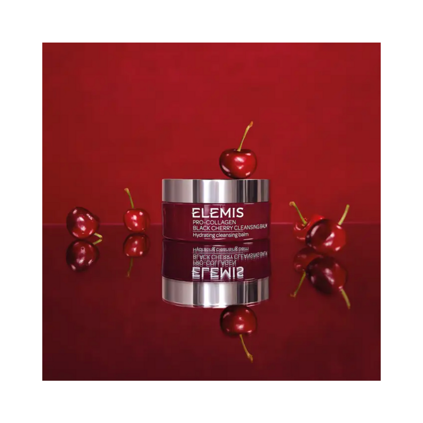 Elemis Pro-Collagen Black Cherry Cleansing Balm-pot met kersen op rode achtergrond, met luxe huidverzorgingsverpakkingen.