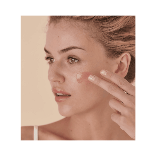 Μοντέλο που απλώνει την κρέμα Embryolisse Radiant Complexion Cream στο μάγουλο, με λεία υφή και φυσικό αποτέλεσμα λάμψης για ενυδάτωση και λάμψη προσώπου.