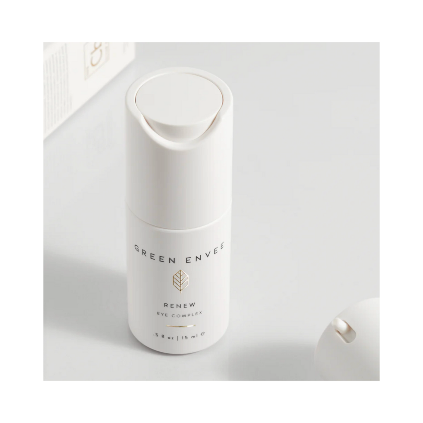 زجاجة Green Envee Renew Eye Complex ذات غطاء مفتوح على سطح نظيف، تسلط الضوء على فوائدها المضادة للتجاعيد وتقليل الهالات السوداء.