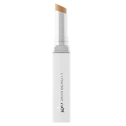 光沢のある白いツイストアップ チューブに入ったサリチル酸配合の Glo Skin Beauty Spot Treat Concealer です。デュアルアクションフォーミュラがニキビを治療しながらシミを隠します。