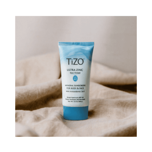 أنبوب TiZO Ultra Zinc Mineral Sunscreen SPF 40 غير ملون بوزن 100 جرام موضوع على قماش محايد، مثالي لحماية البشرة الحساسة.