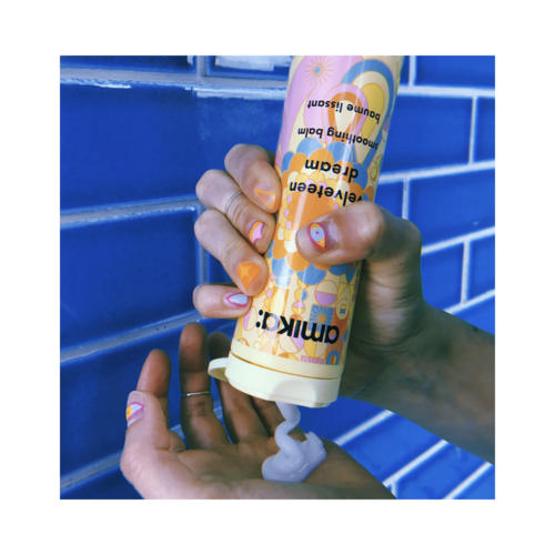 יישום של Amika Velveteen Dream Smoothing Balm - פתרון אילוף שיער מצינור ליד, מושלם לעיצוב שיער חלק וחלק.