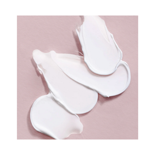 La textura cremosa de la mascarilla capilar voluminizadora Philip B Weightless se muestra sobre una superficie rosa suave, ideal para un tratamiento capilar ligero.