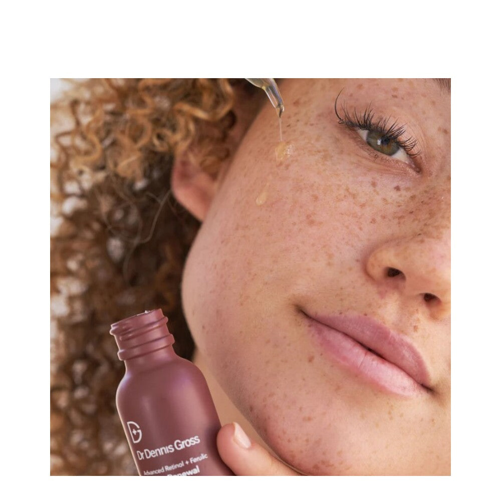 Freckled woman applying Retinol Texture Renewal Serum with dropper, targeting uneven skin tone and fine lines.