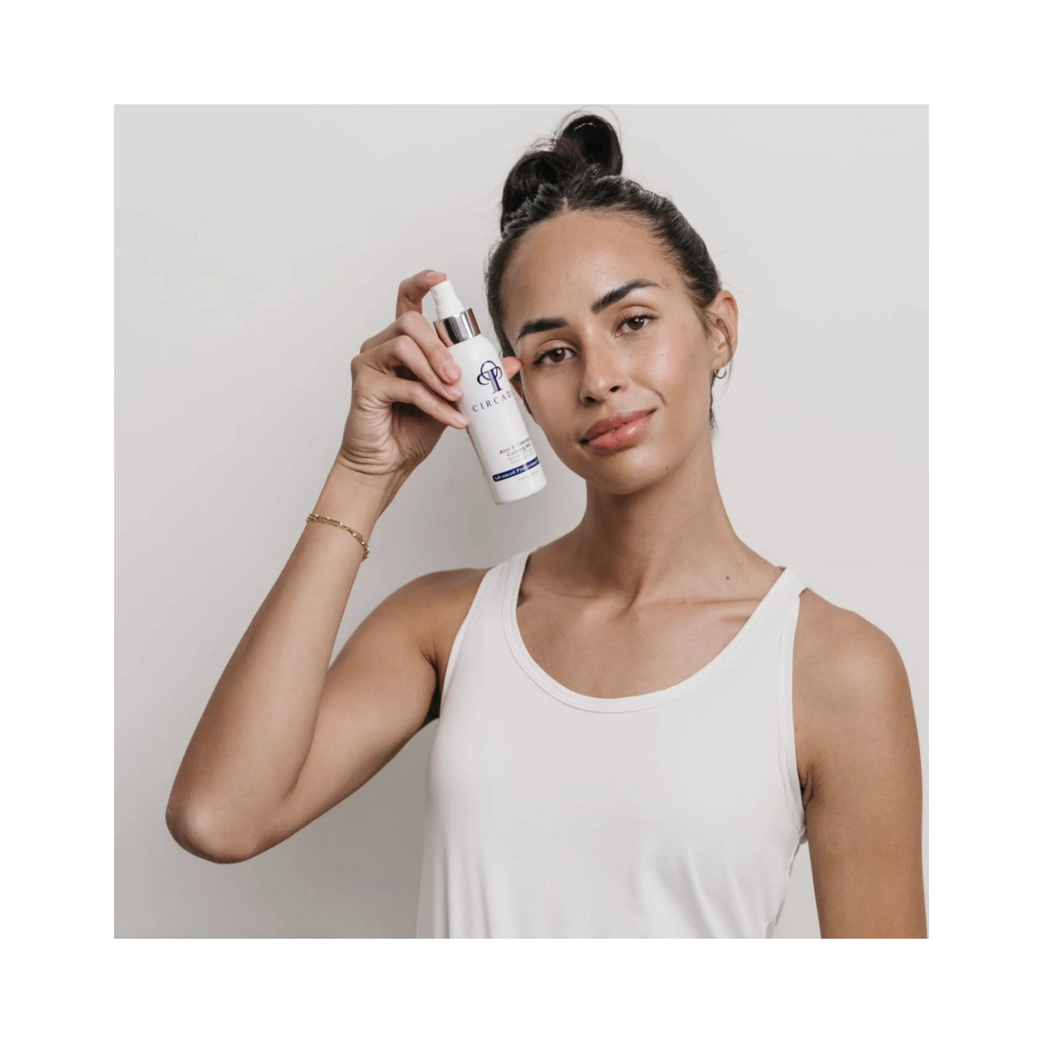 Model holding Circadia Aloe and Calendula Calming Mist, showcasing its use for calming facial redness and sensitive skin. Shop now at eSkinCareStore.