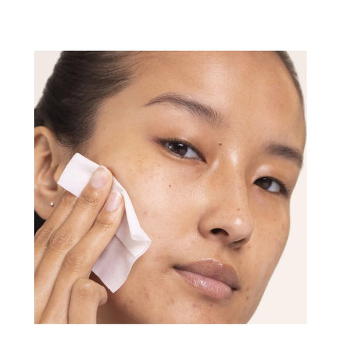 Close-up of woman using Alpha Beta Daily Peel pad by Dr Dennis Gross, targeting uneven texture and dullness for a youthful glow.