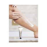 Woman in towel applying Olverum Body Polish to arm. Nourishing exfoliator with bamboo and rose for soft, healthy skin.