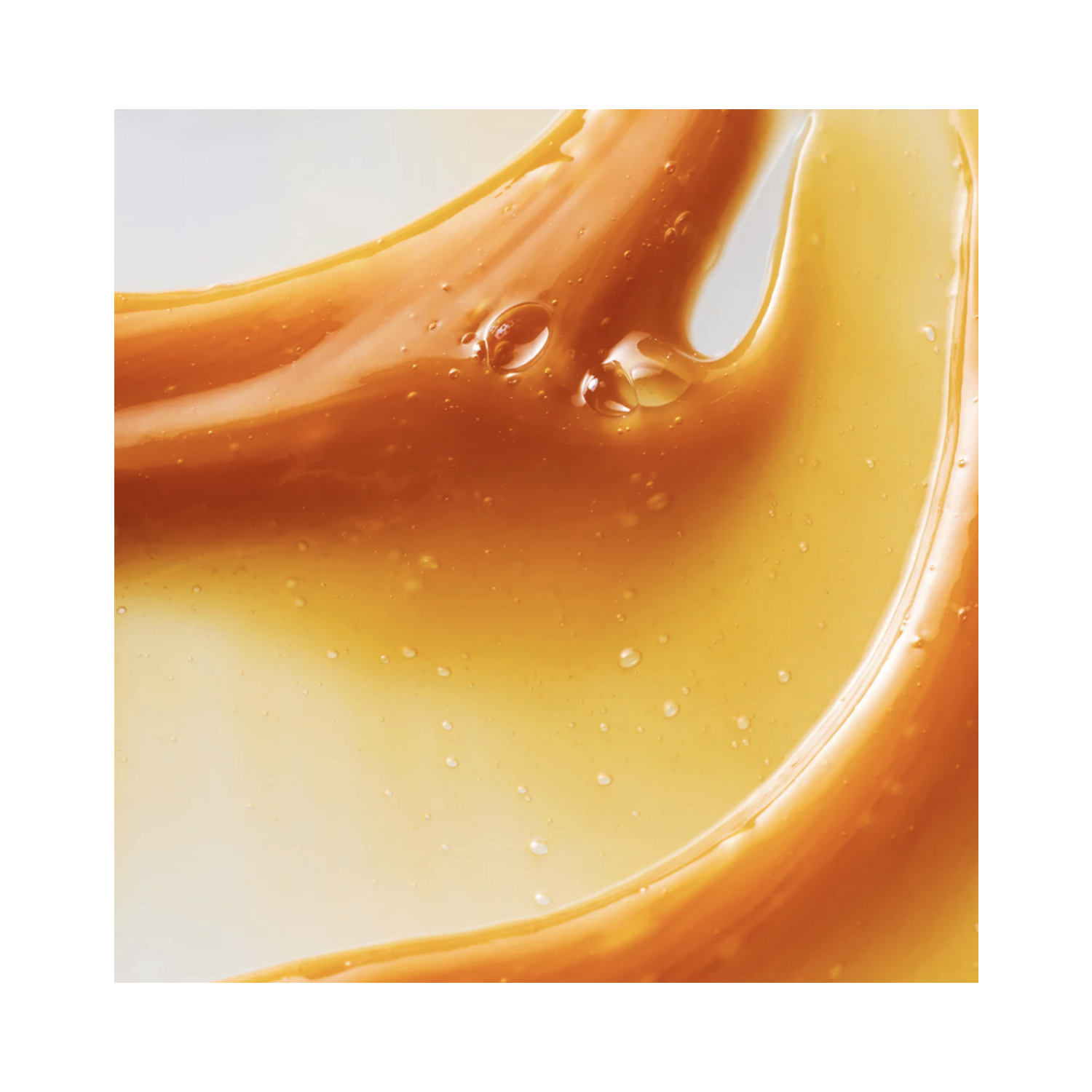Close-up texture of Philip B Botanical Chai Body Wash showing rich, golden gel consistency with hydrating ingredients like honey and soymilk.