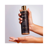 Hand dispensing Philip B Botanical Chai Body Wash, showcasing its smooth, golden formula for soothing and invigorating skin cleansing.