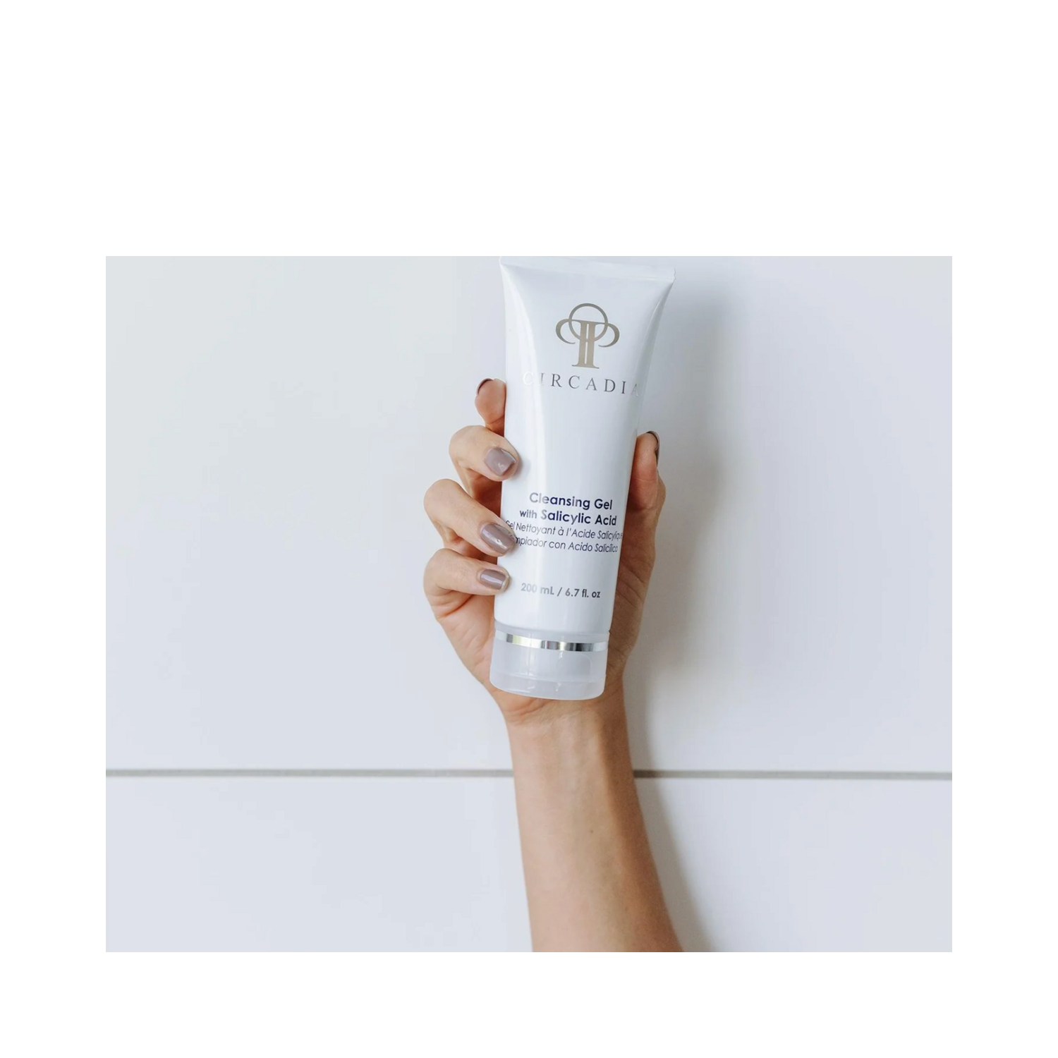 Buy Circadia Cleansing Gel with Salicylic Acid - eSkinStore.com. Hand holding 200ml facial cleanser ideal for oily and acne-prone skin care routines.