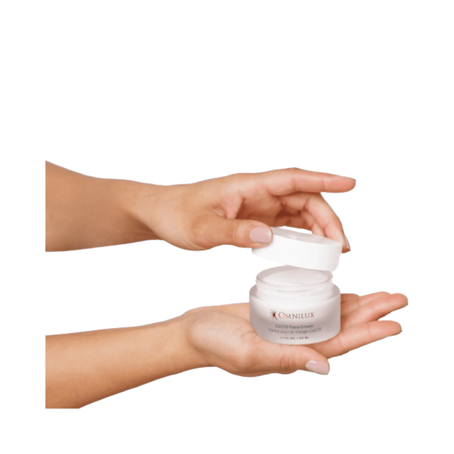 Hands opening Omnilux CoQ10 Face Cream jar, emphasizing creamy texture and ease of application for dry and mature skin.