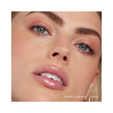 Model wearing Jane Iredale Colorluxe Lip Glaze in Crystal, showcasing a clear, voluminous glossy finish on lips for a natural makeup look.