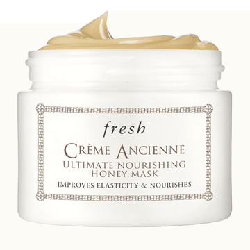 Fresh Creme Ancienne Ultimate Nourishing Honey Mask in white jar with creamy texture. Nourishing honey mask offers 6-hour hydration and intense moisture.