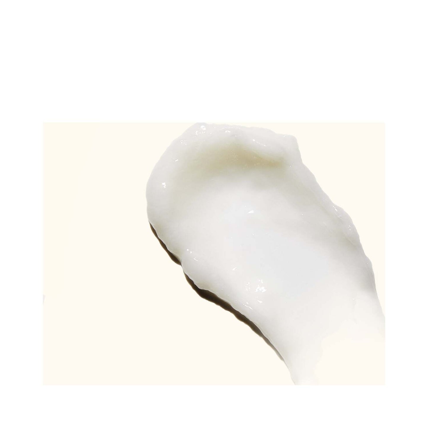 Close-up texture of Amika Curl Corps Defining Cream showing creamy, smooth consistency for moisturizing and defining curls.