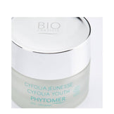 Top view of Phytomer Cyfolia Youth Glow Cream jar with reflective silver lid, emphasizing its organic anti-wrinkle skincare benefits.