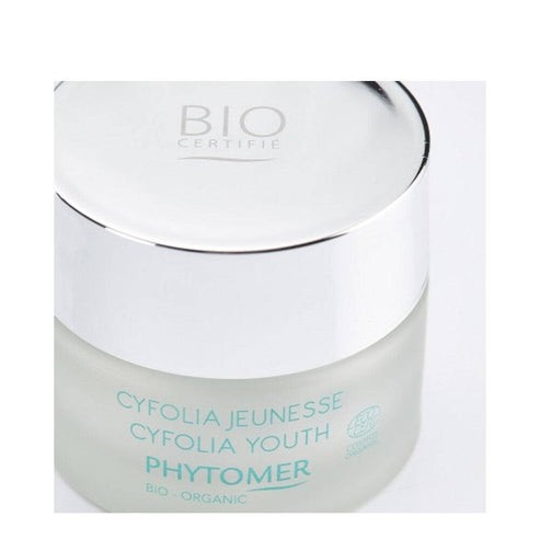 Top view of Phytomer Cyfolia Youth Glow Cream jar with reflective silver lid, emphasizing its organic anti-wrinkle skincare benefits.