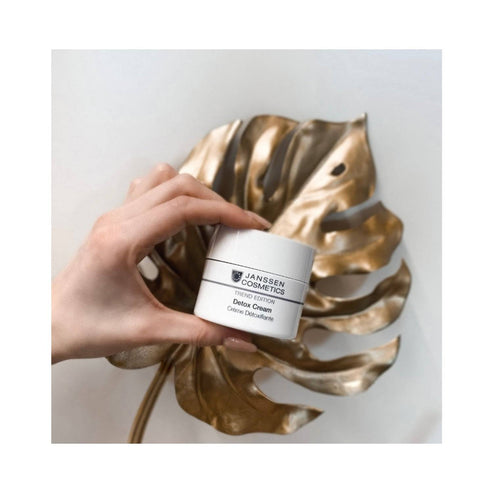 Janssen Detox Face Cream held in hand above gold leaf decor, highlighting premium skincare for detox and hydration with key active ingredients.