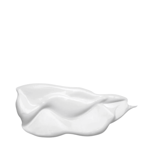 Close-up of Embryolisse Filaderme Emulsion's creamy white texture, showcasing its rich, nourishing formula for dry skin hydration.