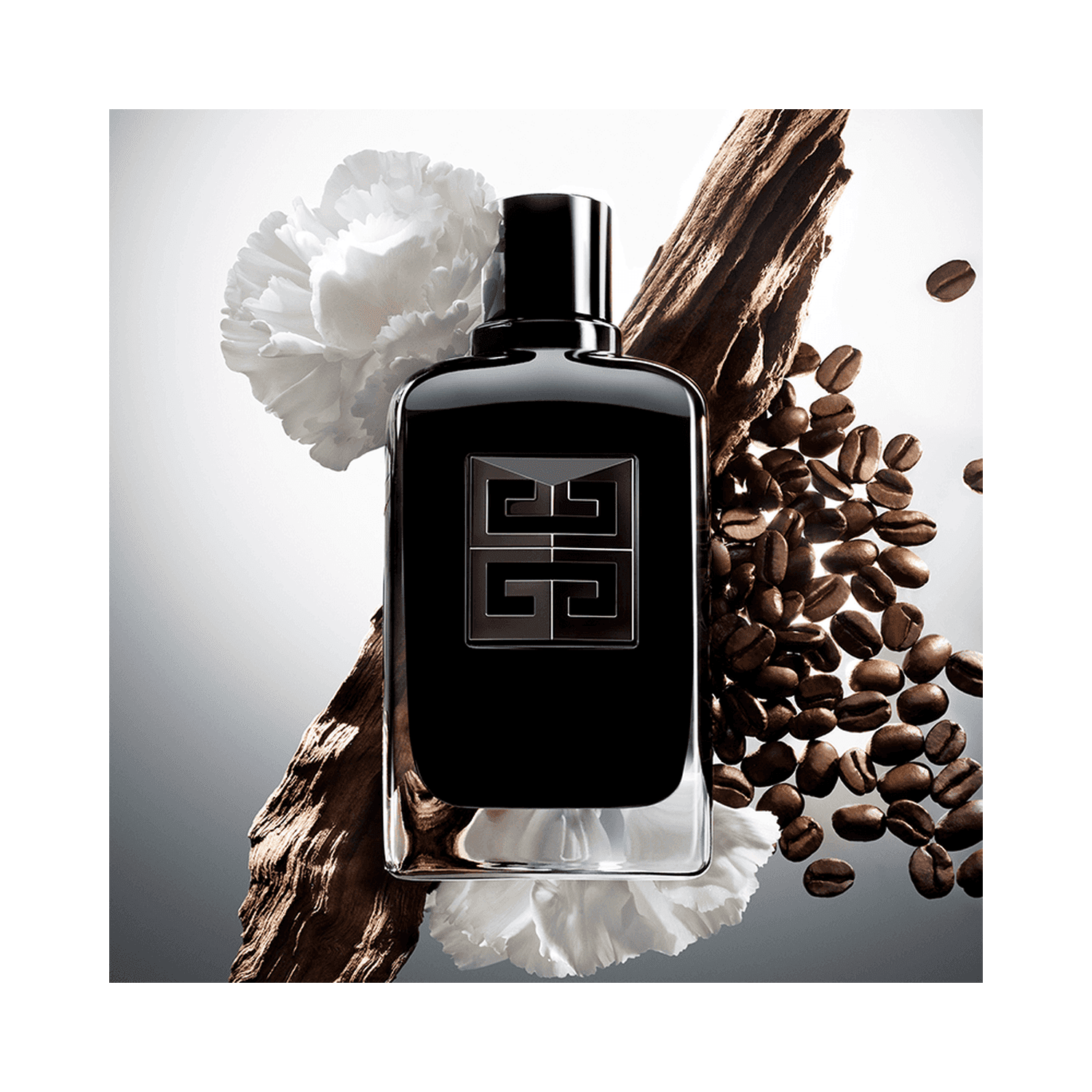 Givenchy Gentleman Society Extreme bottle surrounded by daffodil, wood, and coffee beans. Highlights floral woody fragrance composition.