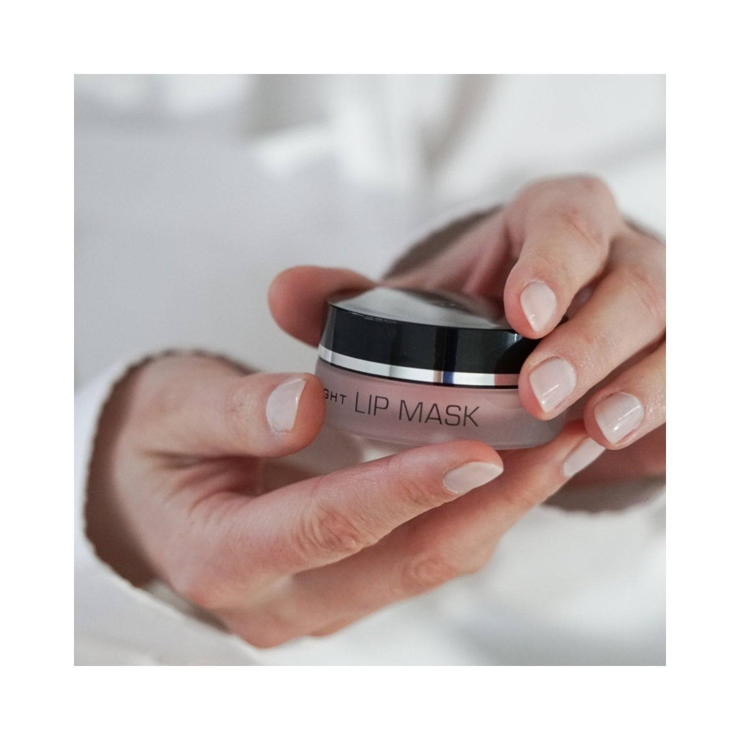 Person holding Janssen Cosmetics Lip Mask jar, showcasing its compact size and suitability for daily lip care routines.