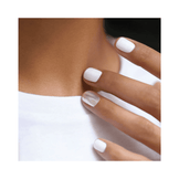 Close-up of nails painted with Manucurist Green Flash Snow, showcasing a glossy white finish on a hand near the neckline.