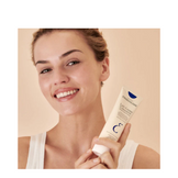 Smiling woman holding Embryolisse Cream, showcasing its popularity and effectiveness as a dermatologist-favorite face moisturizer.