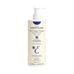 Mulher aplicando o hidratante Embryolisse Lait Creme Fluid - Skincare Essentials nos ombros, apresentando textura cremosa para alívio da pele seca.