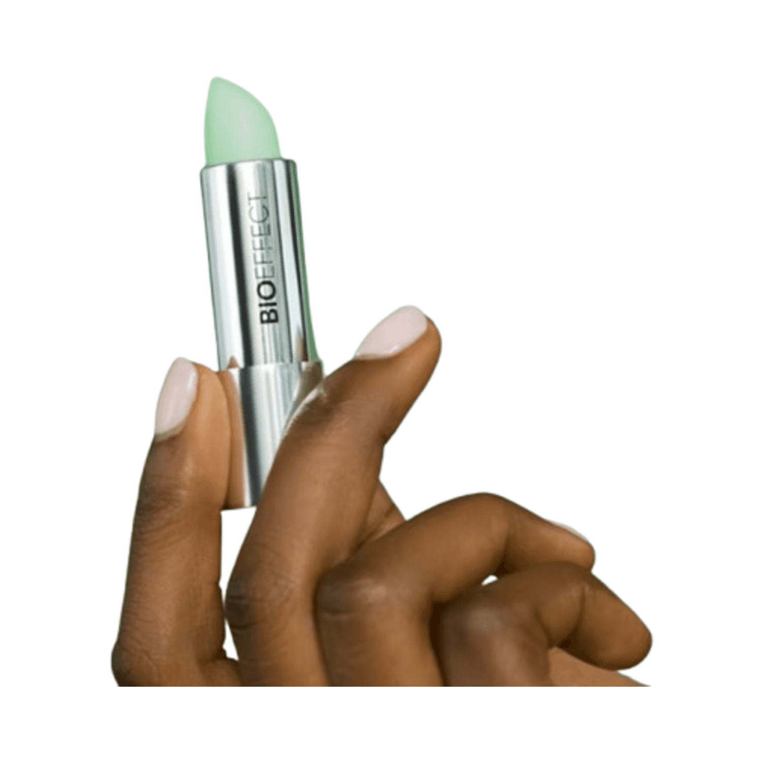 Hand holding BIOEFFECT Lip Balm with mint green tip and silver casing, perfect for hydrating and softening lips on the go.