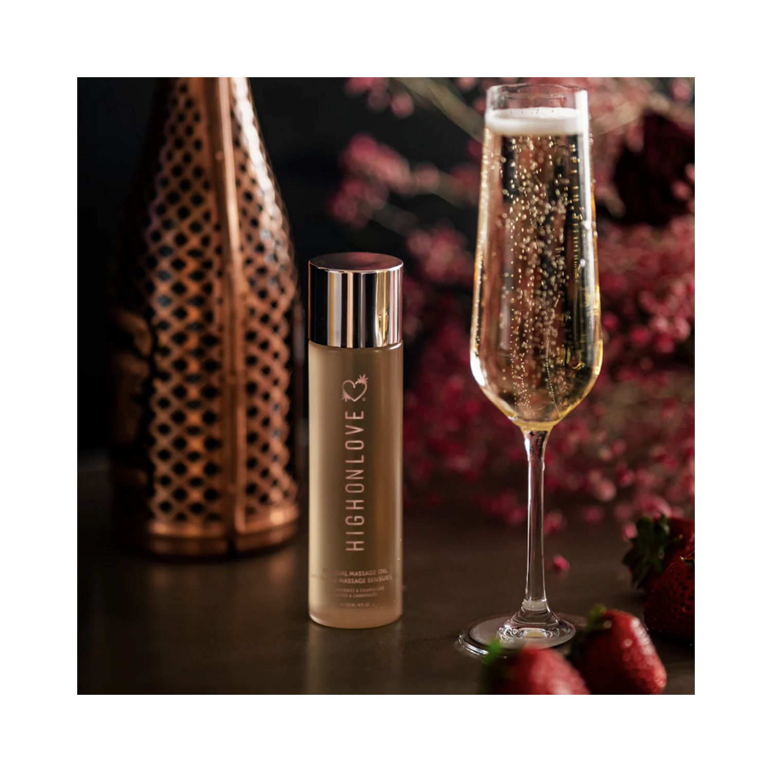 High on Love Massage Oil Decadent White Chocolate Body Oil next to champagne and strawberries, perfect for romantic body care rituals.