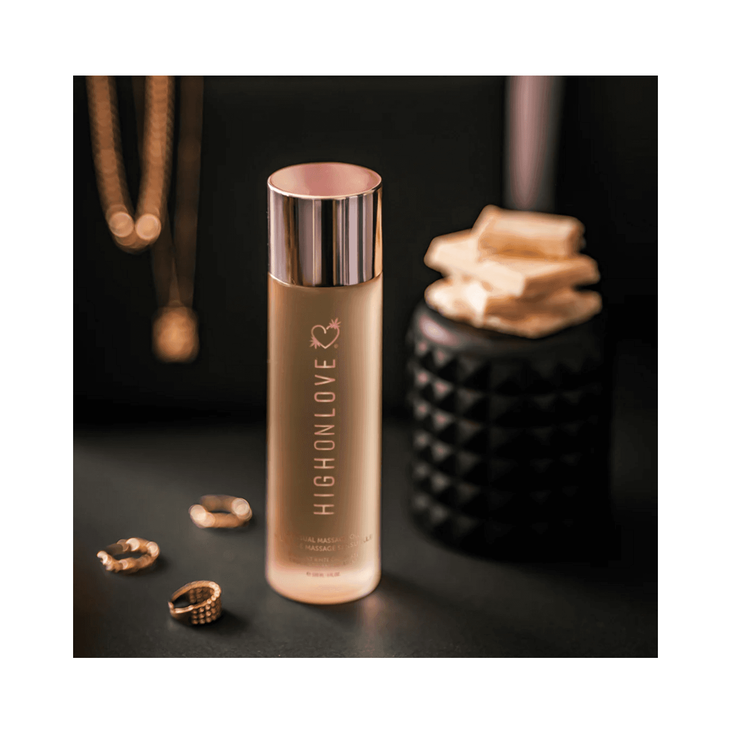 High on Love Massage Oil Lychee Martini Body Oil placed with jewelry and decor, emphasizing its premium body care category.