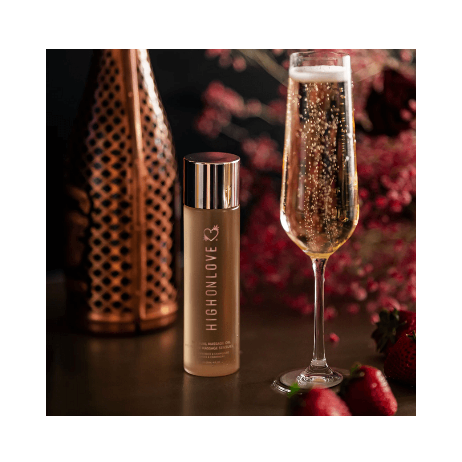 High on Love Massage Oil Strawberries and Champagne Body Oil next to champagne glass and strawberries, ideal for romantic body care.