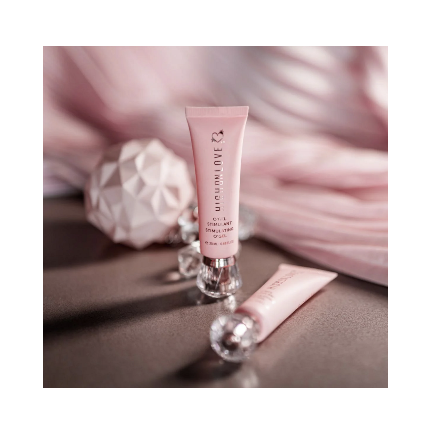 High on Love Mini Stimulating O Gel Body Oil displayed aesthetically with soft pink decor, highlighting luxury personal care appeal.