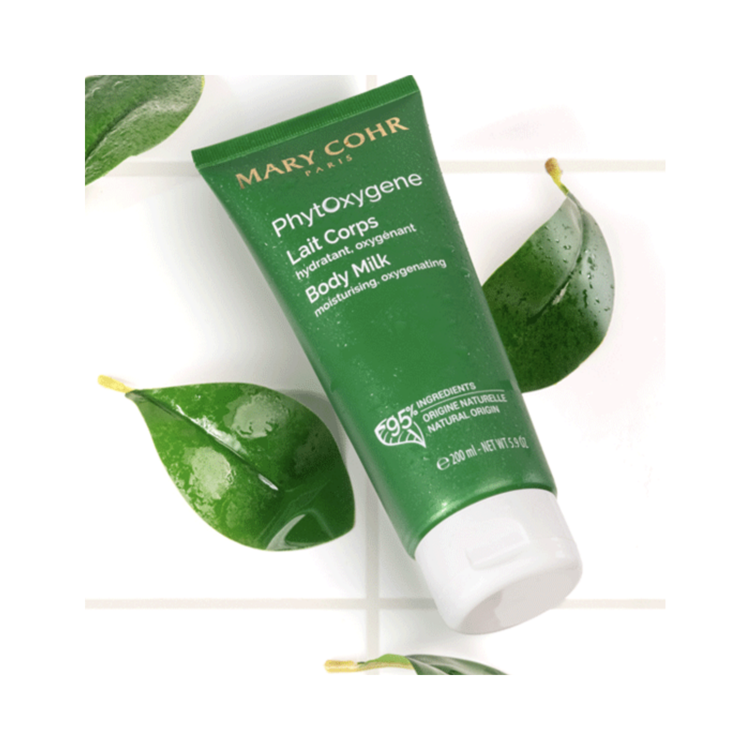 Mary Cohr Phytoxygene Body Lotion displayed on white tiles with green leaves, highlighting its natural ingredients and moisturising benefits.