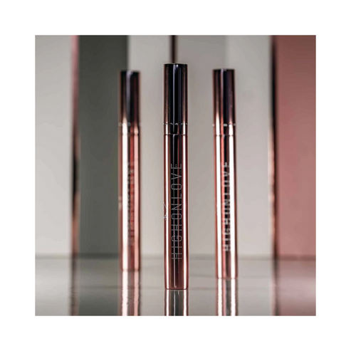 Three High on Love Plumping Lip Gloss tubes on reflective surface, premium lip balm & treatments from eSkinStore for lip care.