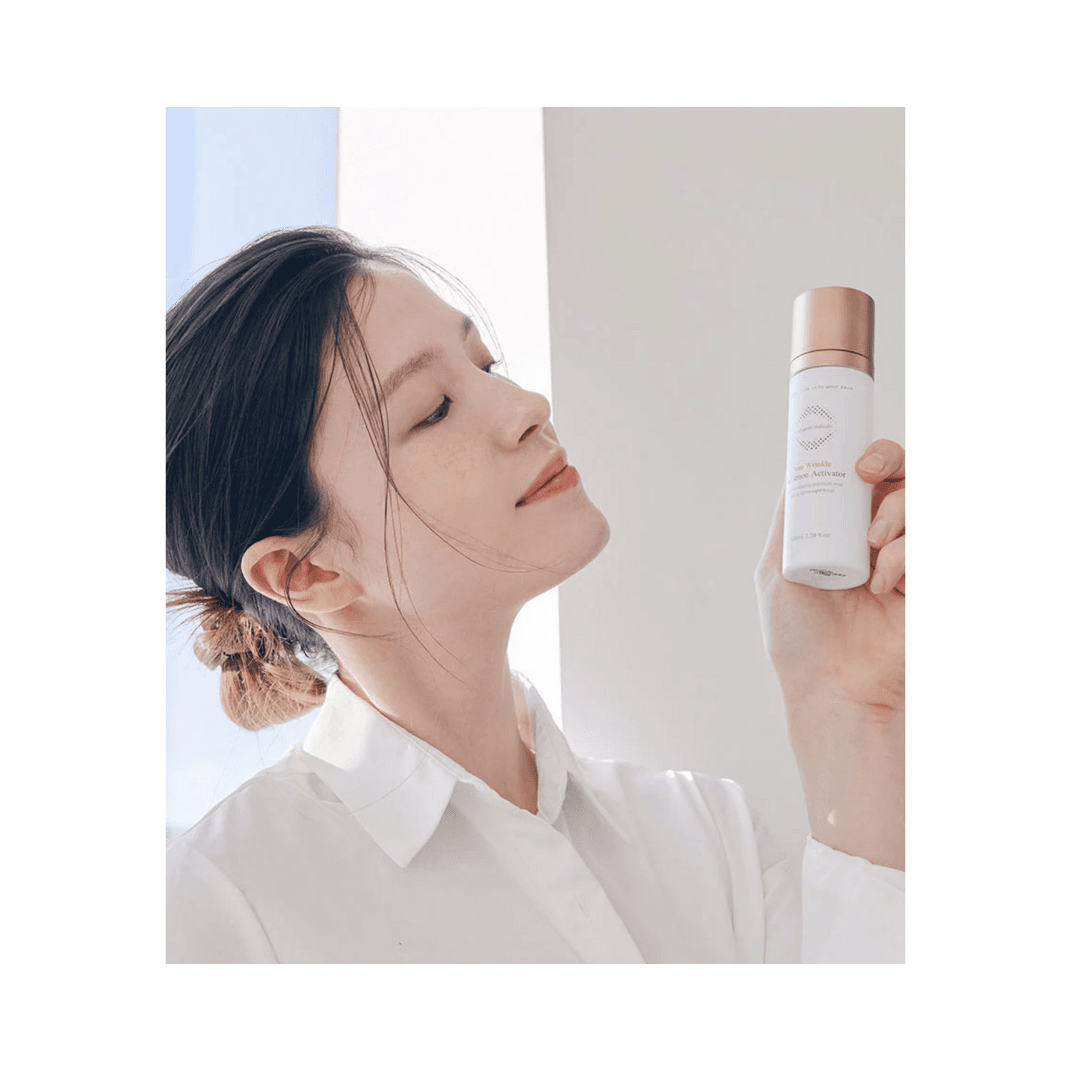 Woman holding OxygenCeuticals ReGenon Activator Face Mist, showcasing its lightweight, anti-wrinkle formula ideal for firming and moisturizing skin.