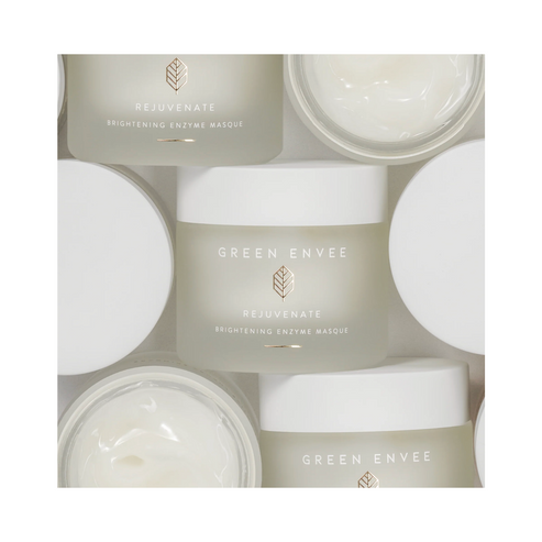 Flat lay of Green Envee Rejuvenate Brightening Enzyme Face Mask jars with open lids. Brightening enzyme face mask for skin care routines.