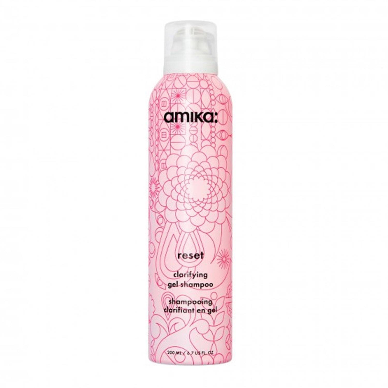Amika Reset Clarifying Gel Shampoo in a pink floral bottle, designed to remove buildup and refresh hair with charcoal and rose extracts.