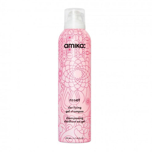 Amika Reset Clarifying Gel Shampoo in a pink floral bottle, designed to remove buildup and refresh hair with charcoal and rose extracts.