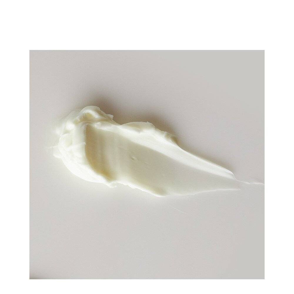 Thick, smooth application of Bioelements Sleepwear night cream, highlighting its hydrating and anti-aging properties for dry facial skin.