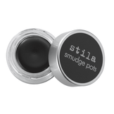 Stila Smudge Pot Jet Black eyeliner in an open round jar with silver lid, ideal for creating sultry eyes and dramatic makeup looks.