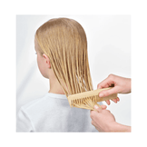 Hair being detangled effortlessly with wide-tooth comb after applying Phyto Detangling Hair Milk. Perfect for family use and daily hair care.