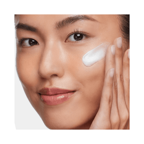 Woman applying HydroPeptide Solar Dew SPF 30 mineral serum to face, showcasing its lightweight, fast-absorbing formula for radiant skin.