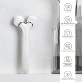 White Geske Sonic Facial Roller displayed on bathroom wall with icons highlighting waterproof design, dermatologist approval, and magnetic charging.