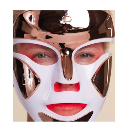 User wearing Dr Dennis Gross LED FaceWare Pro mask with red light therapy activated to stimulate collagen and reduce fine lines.